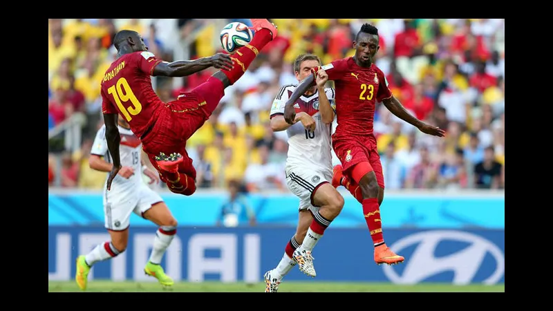 Cầu thủ của Đức và Ghana đá bóng trên sân cỏ