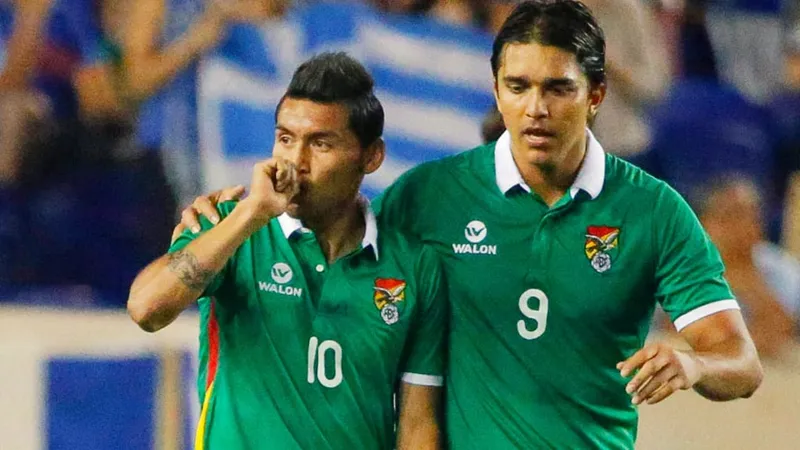 Cầu thủ Iraq đang phòng ngự trước cầu thủ Bolivia trên sân cỏ